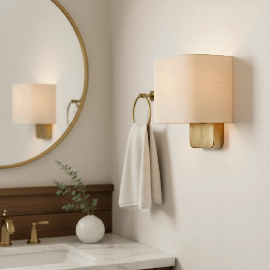 Bathroom with round mirror, wall sconces, sink, and towel.