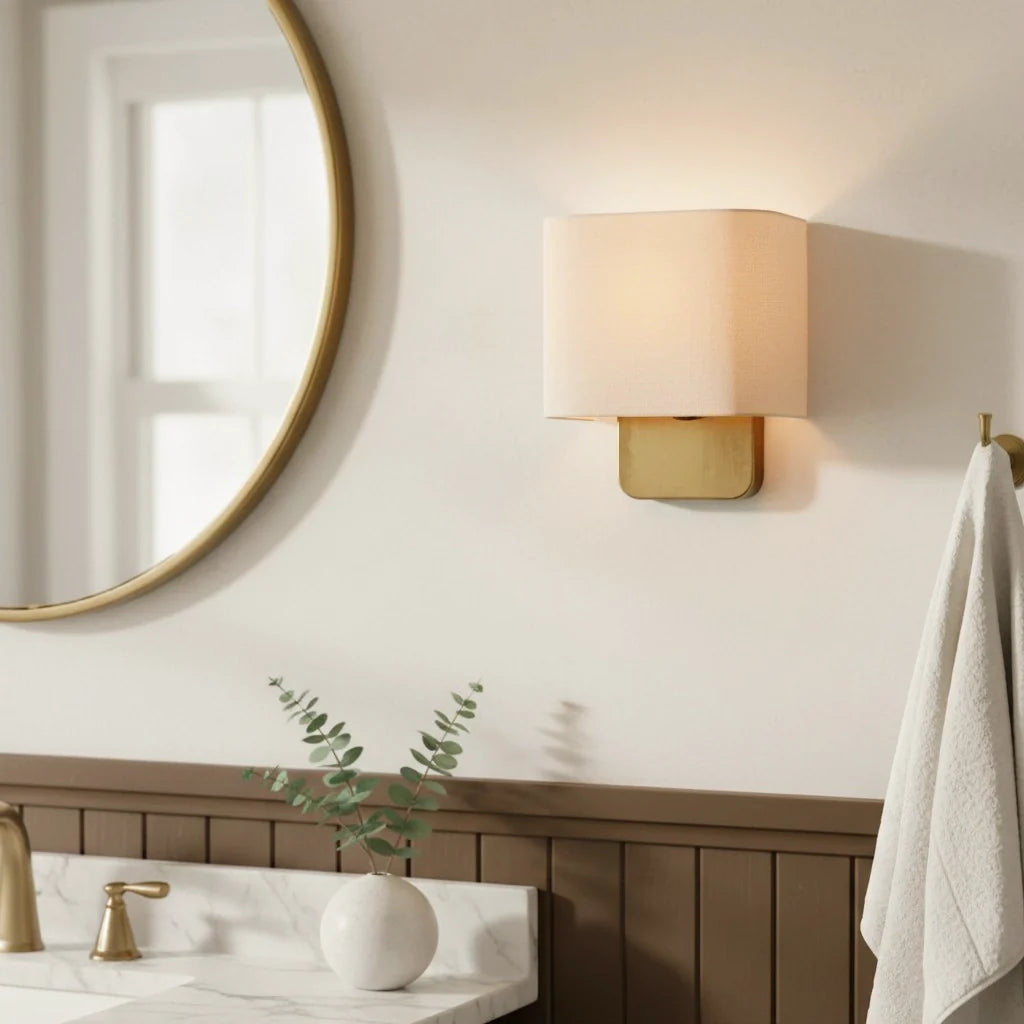 Bathroom interior with a round mirror, wall lamp, towel, and plant.