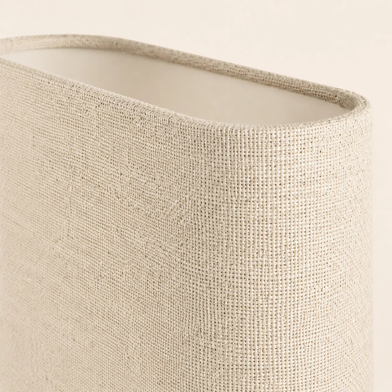 Close-up of a textured beige lampshade on a neutral background