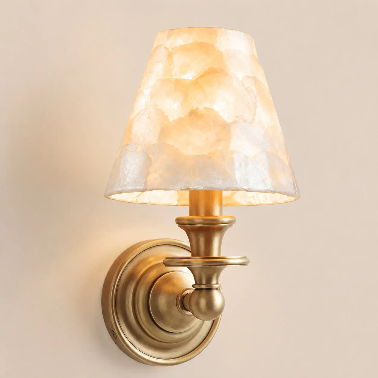 Wall-mounted lamp with a decorative shade on a beige wall