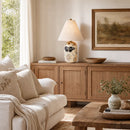 Living room with beige sofa, wooden sideboard, and decorative items.