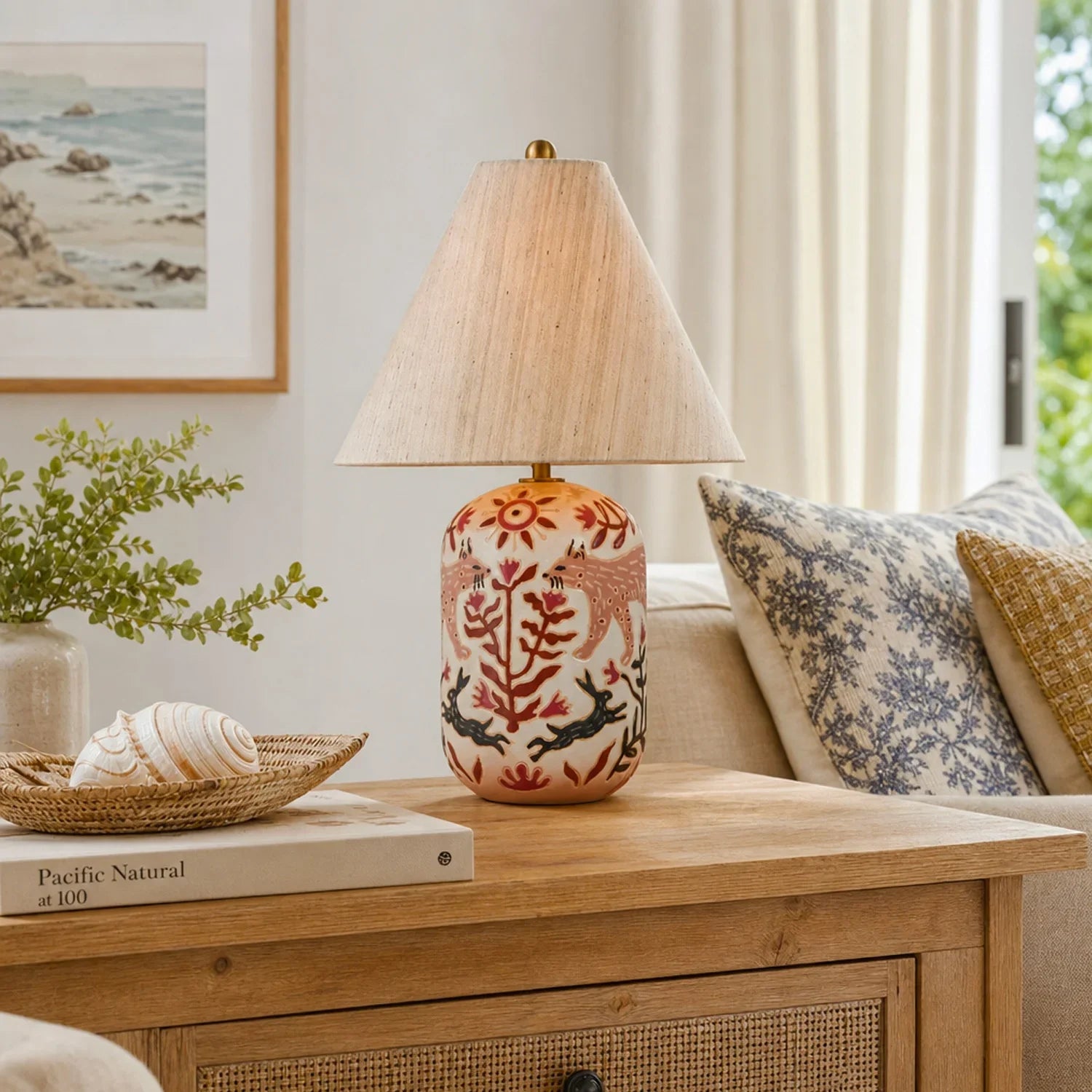Decorative lamp on a wooden table with a couch and painting in the background