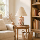 Living room with beige sofa, wooden side table with lamp, bookshelf, and decorative items.
