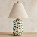 Table lamp with decorative green leaf pattern on a beige background