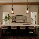 Modern kitchen with marble island, pendant lights, and wooden chairs.