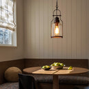 Dining area with a round table, chairs, and a hanging light fixture.