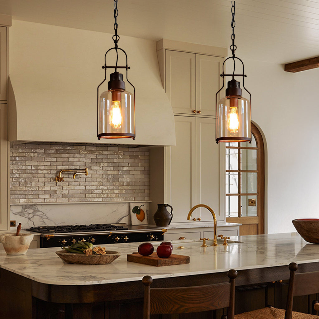 Modern kitchen with pendant lights, marble island, and wooden chairs.