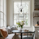 Kitchen nook with a window seat, table, and decorative elements.