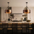 Modern kitchen with pendant lights, island, and chairs.
