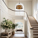 Staircase in a home with white walls, a chandelier, and a view into a living room.