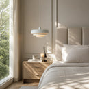 Modern bedroom with a bed, nightstand, and pendant light.