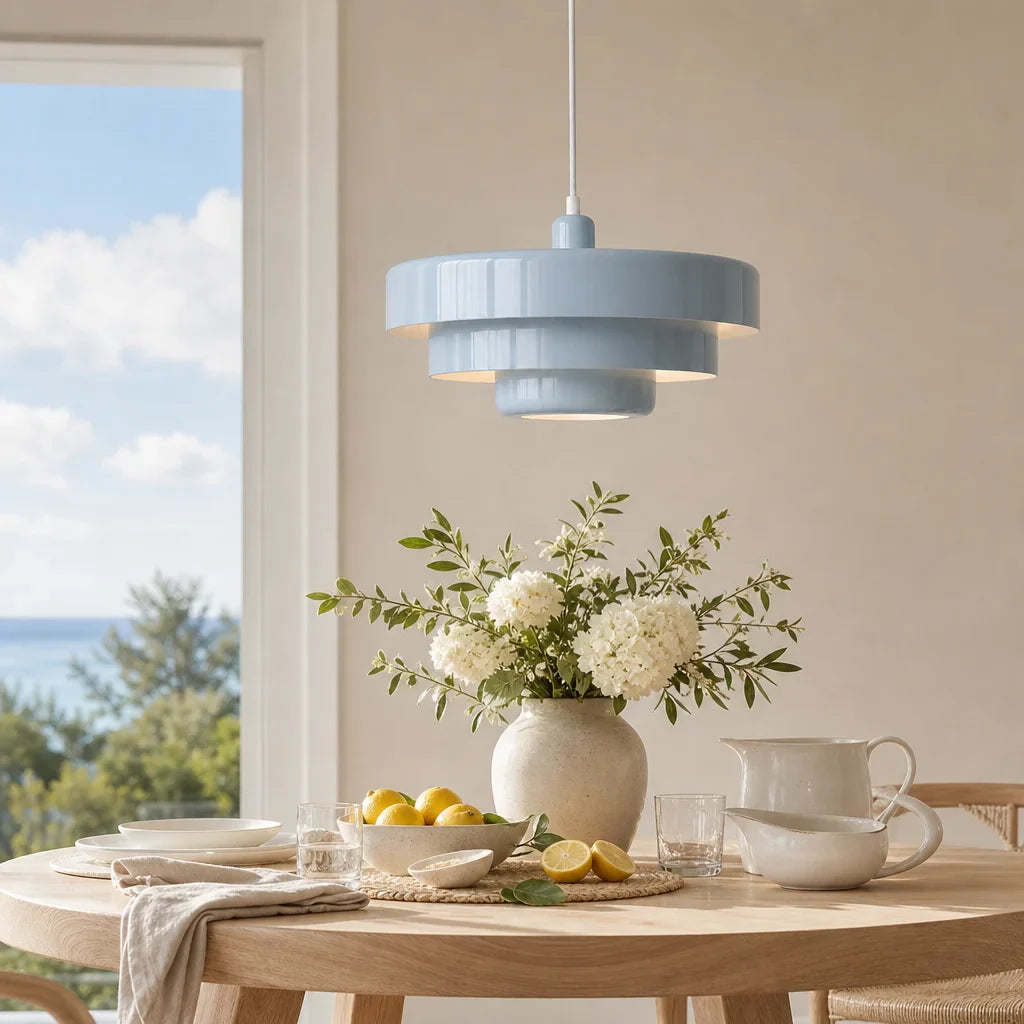 Dining room with a light blue pendant lamp, table setting, and vase with flowers.