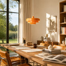 Modern office with wooden desk, chairs, and orange pendant light.