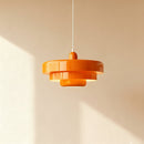 Orange pendant light fixture on a beige background
