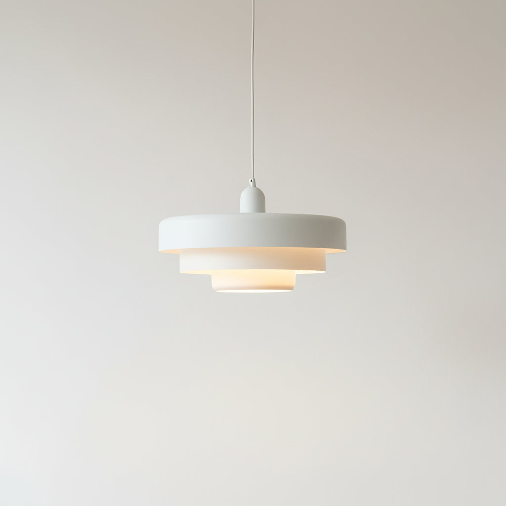 Modern pendant light with a white shade on a plain background