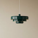Modern pendant light with three circular shades on a beige background