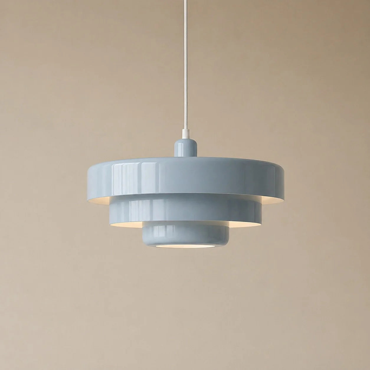 Gray pendant light against a beige background