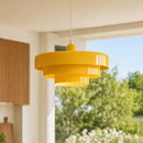 Yellow pendant light hanging in a room with a blurred outdoor view