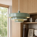 Green pendant light hanging in a room with wooden walls and shelves.