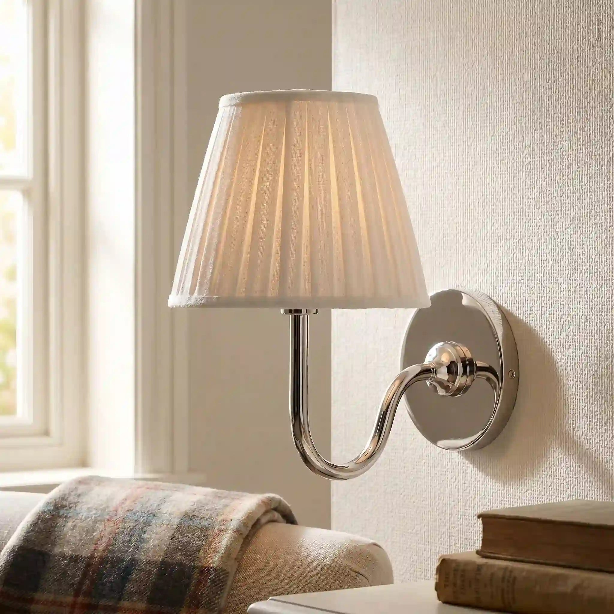 Wall-mounted lamp with pleated shade on a neutral wall