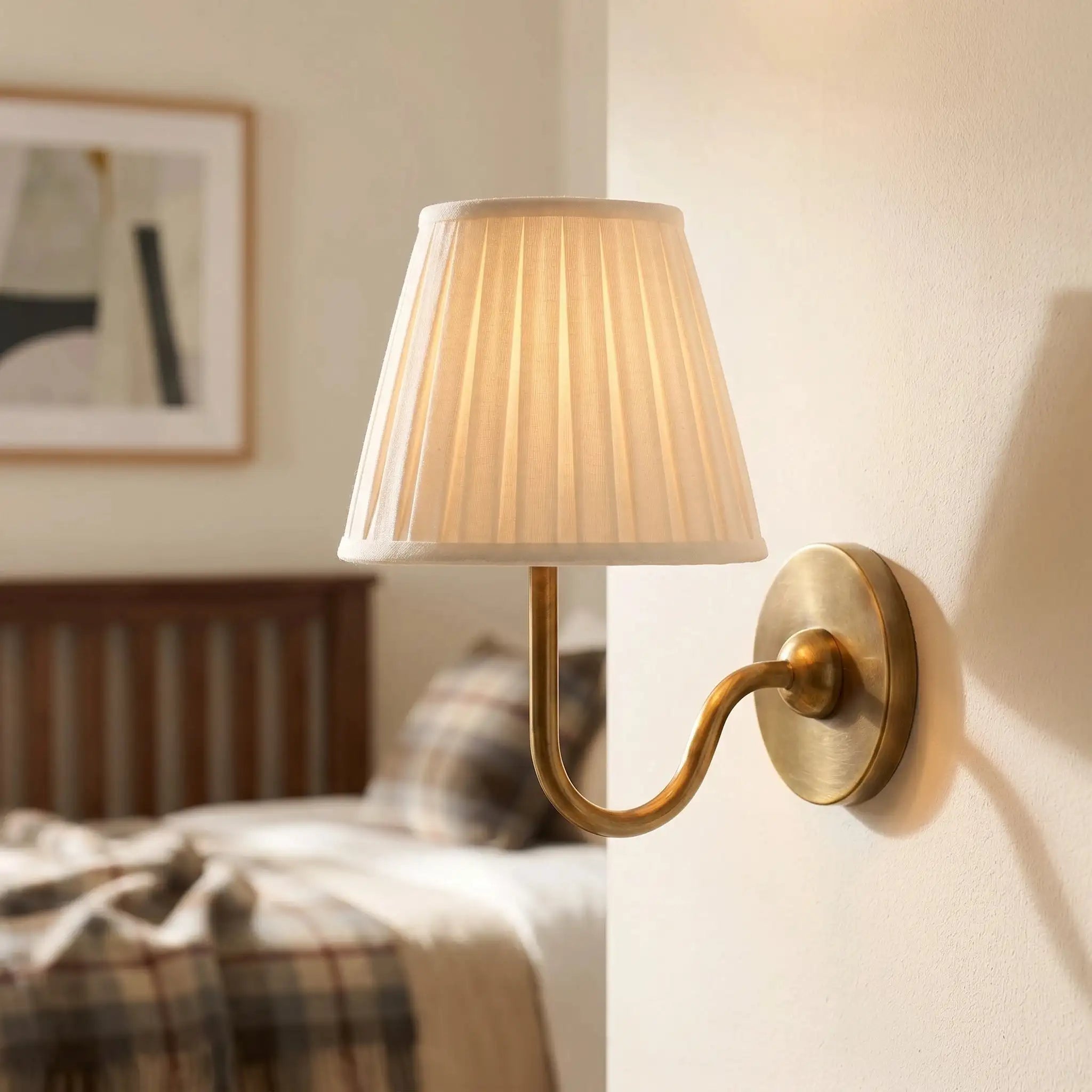 Wall-mounted lamp with pleated shade in a bedroom setting
