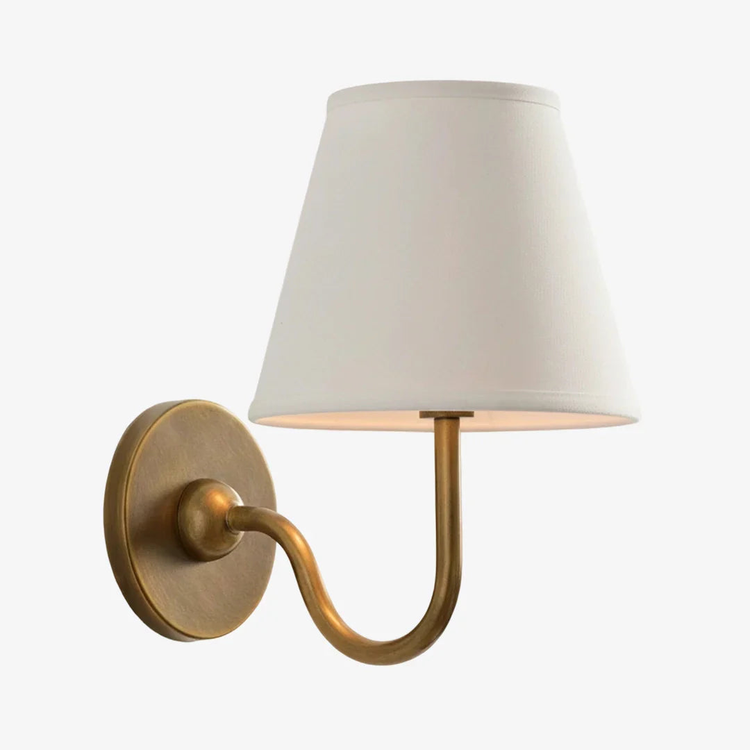 Wall sconce with a white shade and gold fixture on a white background