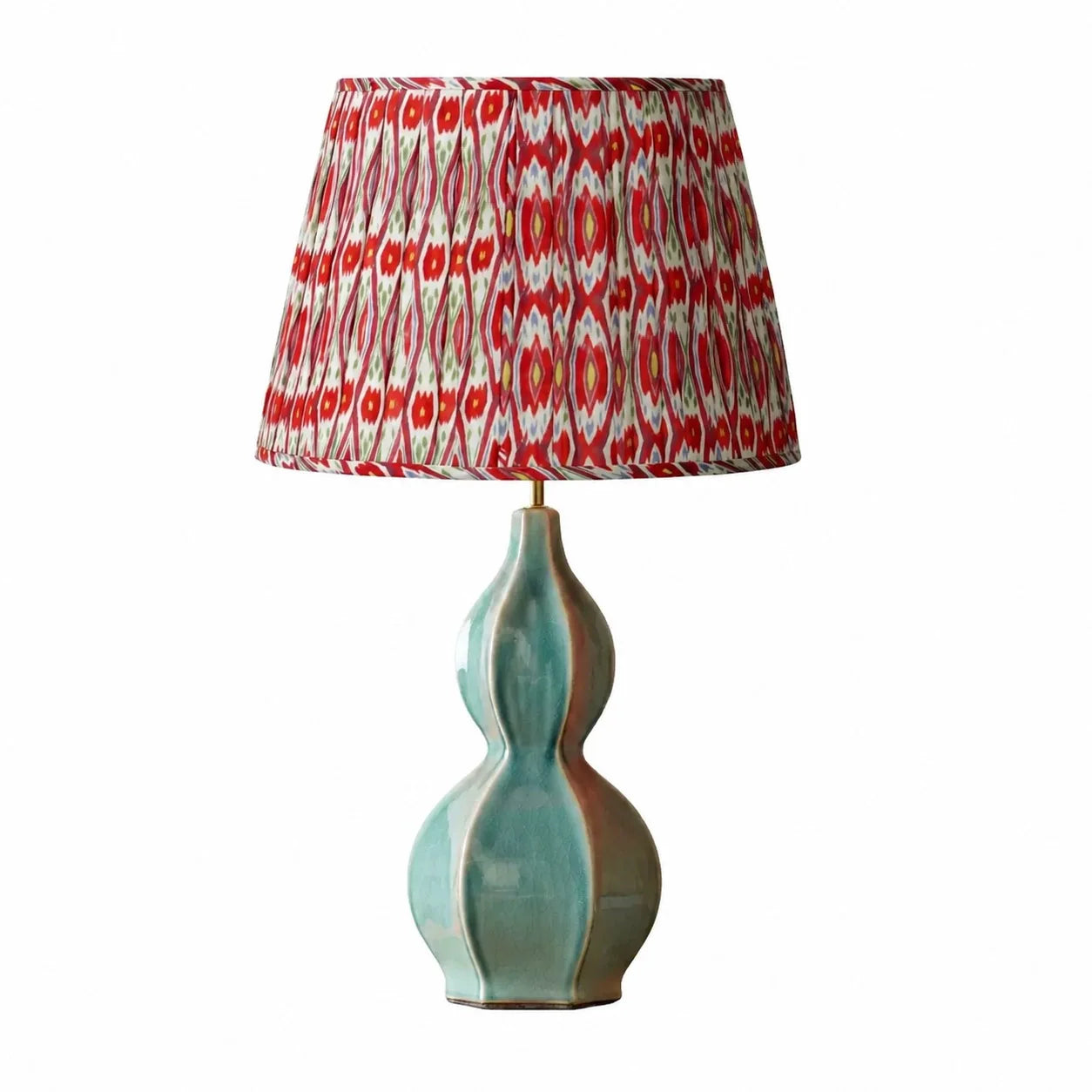 Lamp with a red and white patterned shade on a white background