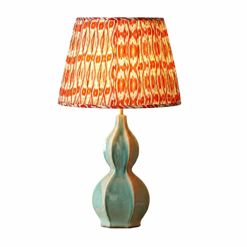 Table lamp with a decorative red and orange shade on a white background