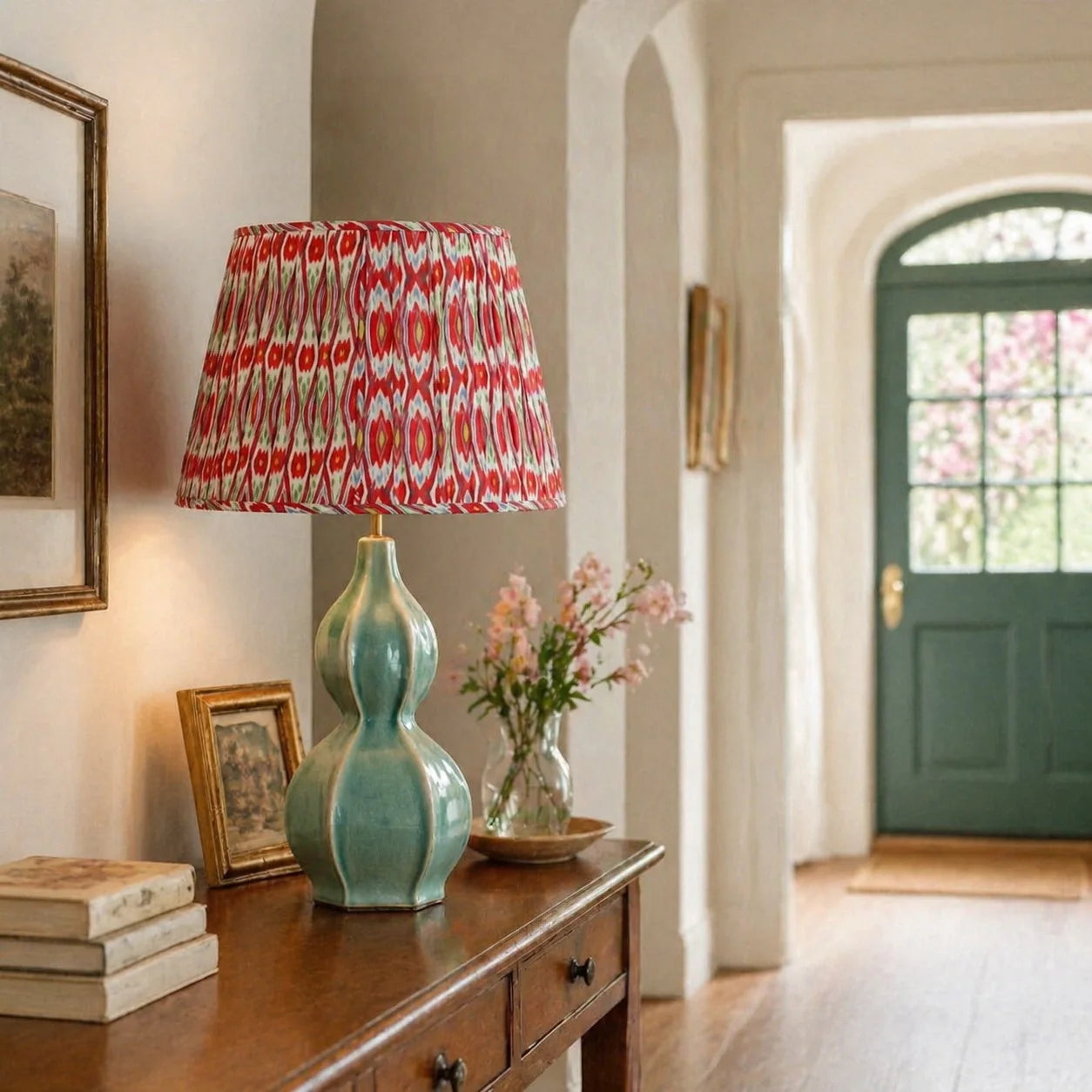 Decorative lamp with a red and white patterned shade on a wooden side table in a home setting.