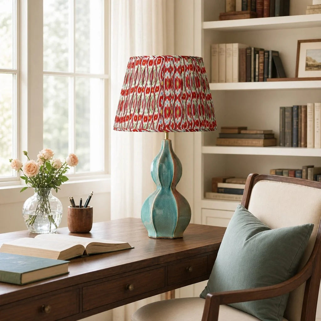 Home office with a wooden desk, lamp, books, and flowers.