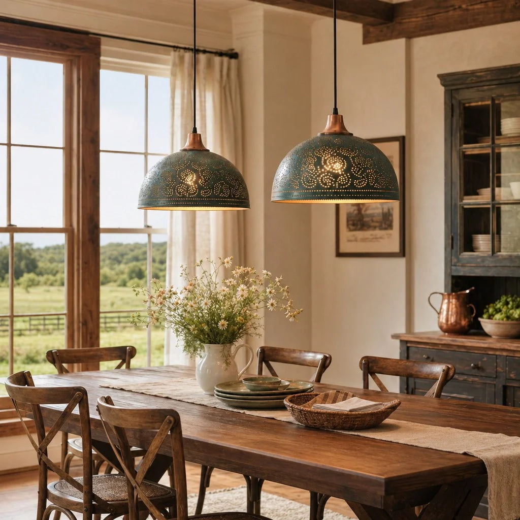Two teal metal pendant lights with gold filigree detailing hang over a rustic wooden dining table in a bright, traditional farmhouse dining room.
