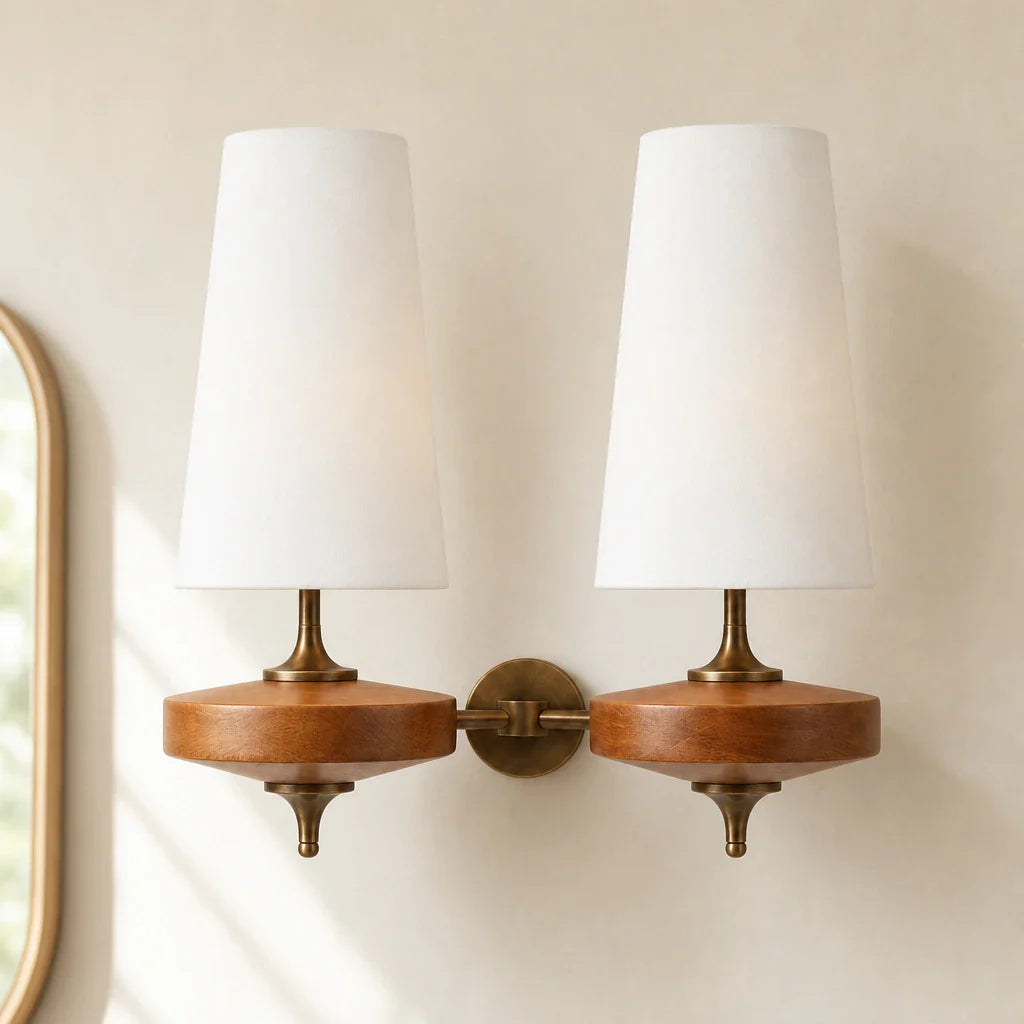 Pair of wall sconces with wooden bases and white lampshades on a neutral wall.