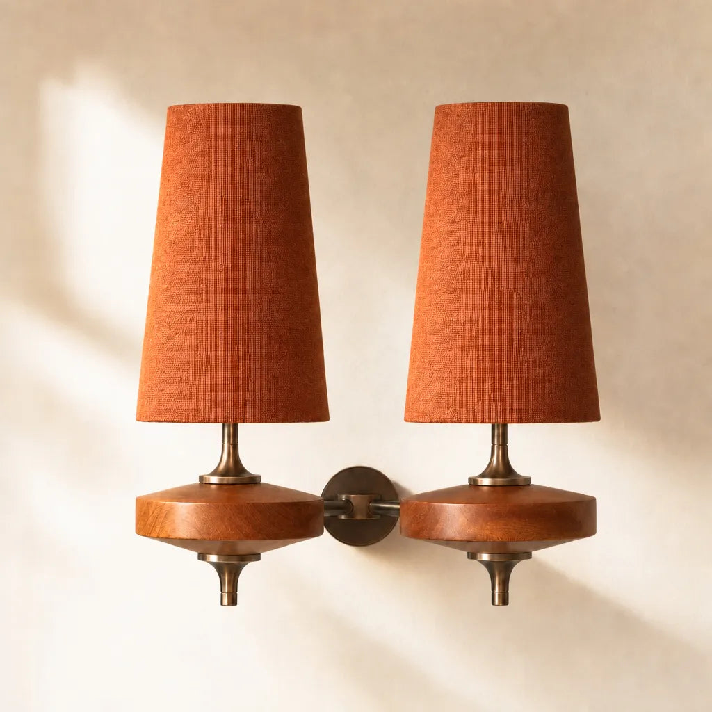 Pair of wall-mounted lamps with orange lampshades on a beige background