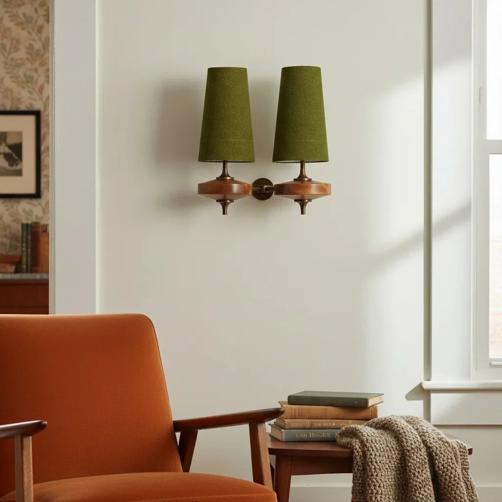 Green wall sconces above an orange armchair in a room with a window and books.