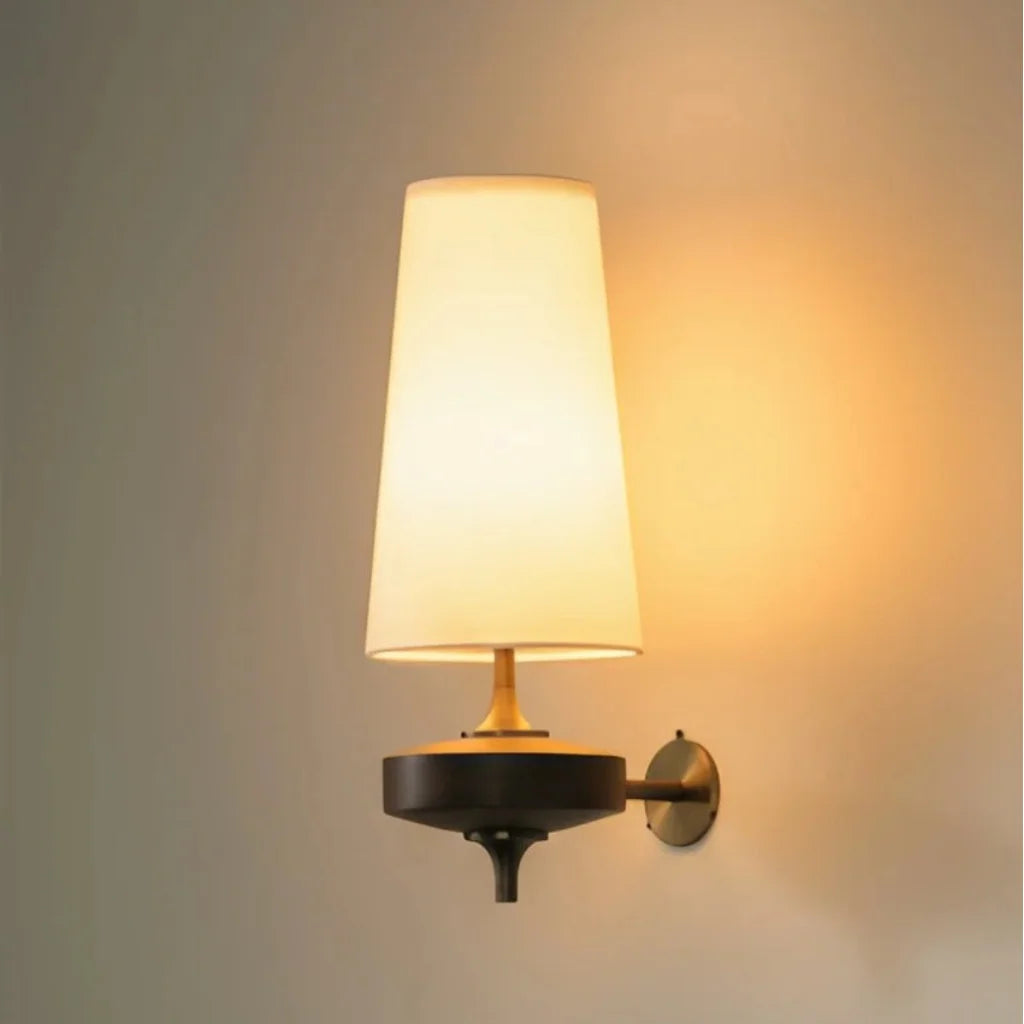 Wall-mounted lamp with a white shade and black base on a neutral background