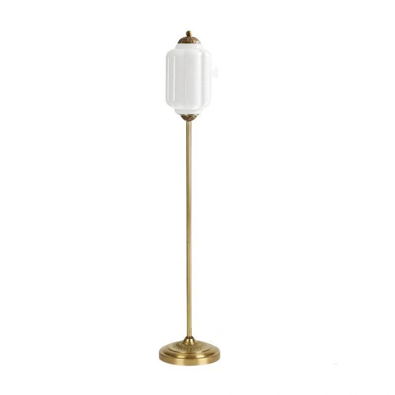 Floor lamp with a white shade and brass base on a white background